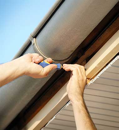 Roofing Pups technician attaching gutters on a Baltimore County residence