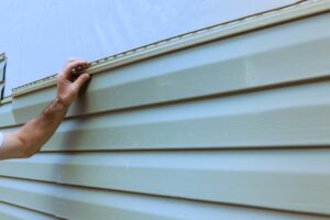 Contractor installs new panels to highlight vinyl siding benefits for Maryland and Virginia homes.