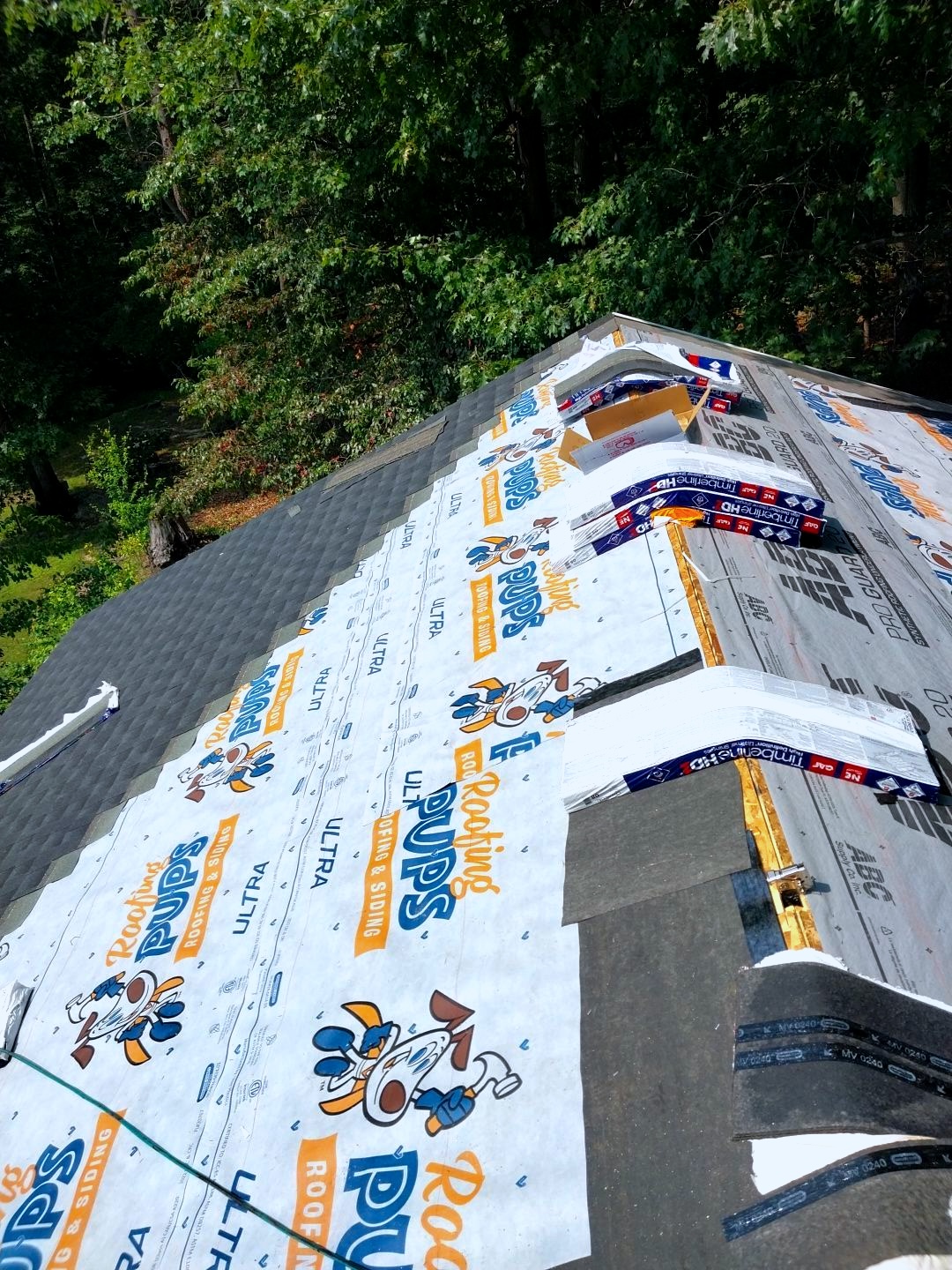 Roofing Pups roof repair project in progress with synthetic underlayment installation and roofing materials staged on a residential roof in Maryland & Northern Virginia.